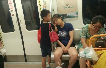 成都地铁小暖男 成都地铁“小暖男”走红：用手为妈妈垫着睡觉